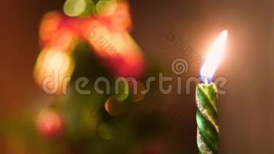 美丽的绿色蜡烛燃烧在平安夜与装饰模糊的圣诞树的背景。 概念